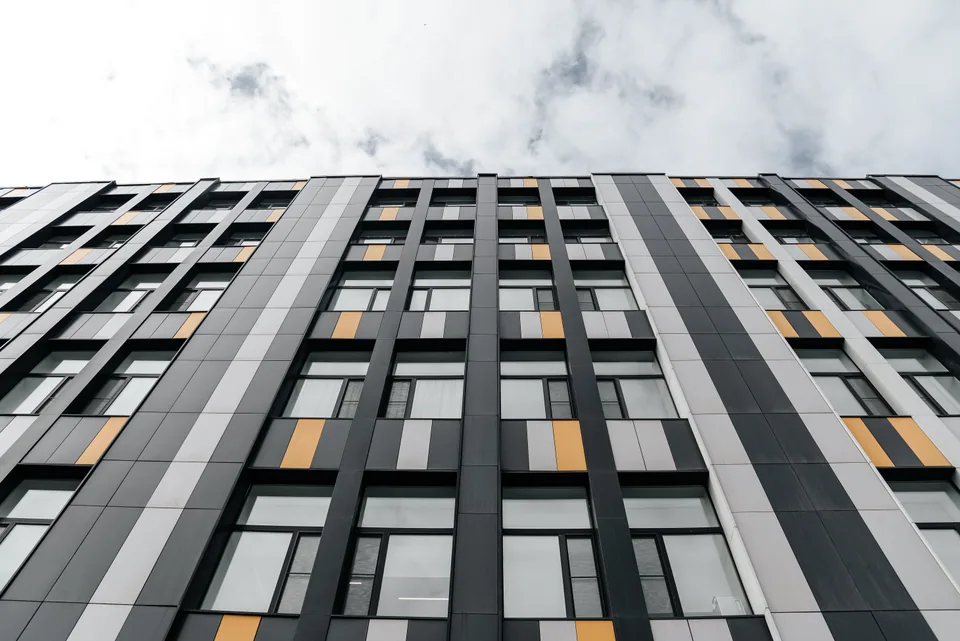 Façade de bureaux habillée de panneaux gris et jaunes.