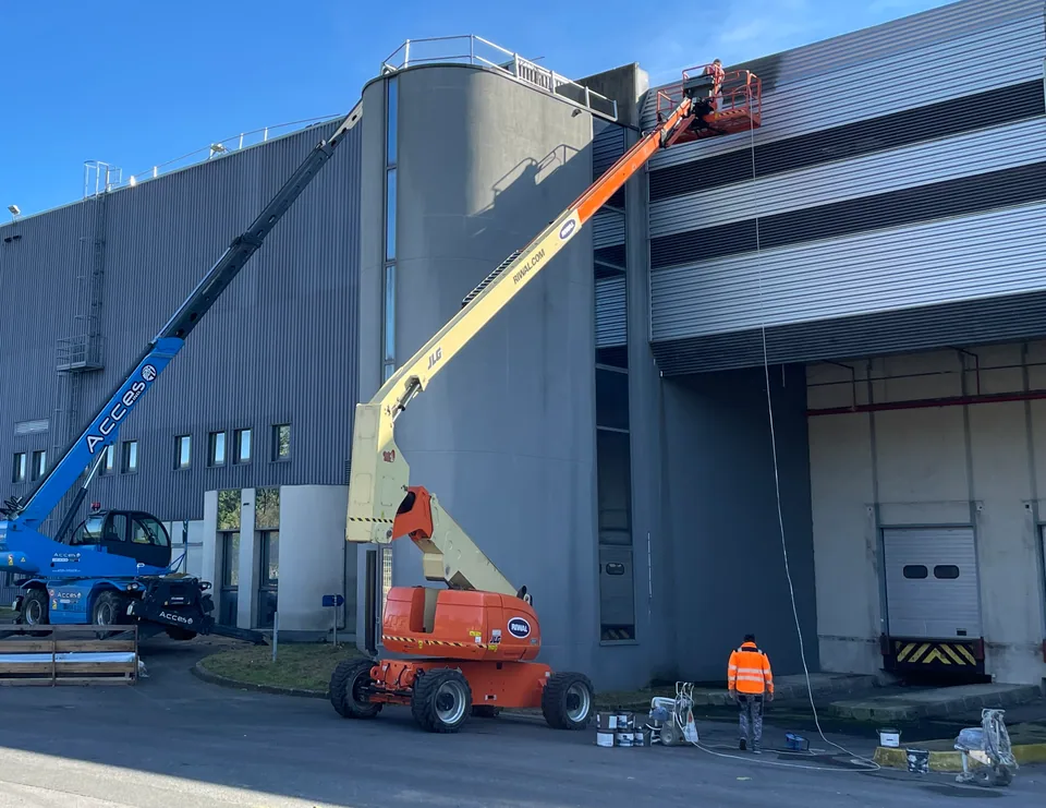 Travaux de peinture de façade avec accès par nacelles.